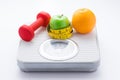 Dieting weight-loss slim down concept. Closeup measuring tape on white weight scale