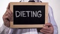 Dieting written on blackboard in doctor hands, nutritionist recommendations