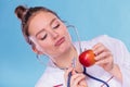 Dietitian examine apple fruit with stethoscope.