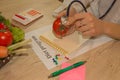 Dietitian nutritionist checking examine a tomato with stethoscope