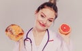 Dietitian with sweet roll bun and grapefruit. Royalty Free Stock Photo