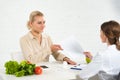 Dietitian in white coat giving paper to patient