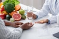 Dietologist giving pills and glass of water to female patient Royalty Free Stock Photo