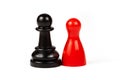 Differences paired togetherness concept, two pieces. Red game piece and a black chess pawn standing together, isolated on white Royalty Free Stock Photo