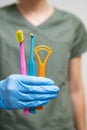 Differenet toothbrushes in dentists hand in rubber gloves.