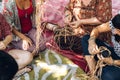 Different ages females weaving bascets on the craft workshop, sitting on a carpet on a flour.