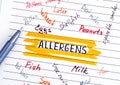 Different allergens written on lined paper with pen.