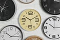 Different analog clocks hanging on white wall.