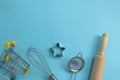 Different baking tools with shopping grocery cart on blue background, top view. Baking and cooking ingredients shopping Royalty Free Stock Photo