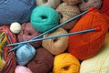 Different balls of woolen knitting yarns and needles as background, top view Royalty Free Stock Photo