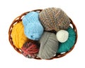 Different balls of woolen knitting yarns in wicker basket on white background, top view Royalty Free Stock Photo