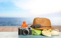 Different beach objects on wooden surface near sea