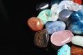 Different beautiful gemstones on black background. Space for text Royalty Free Stock Photo