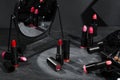 Different beautiful lipsticks and mirror on grey table
