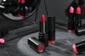 Different beautiful lipsticks and mirror on grey marble table, closeup