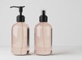 Different beige glass bottles for hair and body care products 3D render, set of cosmetic containers on gray studio Royalty Free Stock Photo