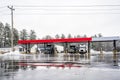 Different big rig semi trucks with semi trailers refuel tanks at a gas station on a truck stop with melting snow at winter time Royalty Free Stock Photo