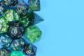 Different blue and green roleplaying RPG dice on side of blue background Royalty Free Stock Photo