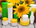 Different body care cosmetics and sunflowers in wicker basket