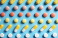 Different bright pills on color background