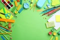 Different bright school stationery on  green background, flat lay. Space for text Royalty Free Stock Photo