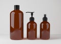 Different brown glass bottles for hair and body care products 3D render, set of cosmetic containers on gray studio Royalty Free Stock Photo