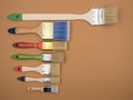 Different brushes for painting on a beige background.