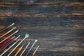 Different brushes to paint on dark wooden background, top view. Royalty Free Stock Photo