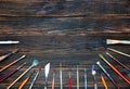 Different brushes to paint on dark wooden background, top view. Royalty Free Stock Photo