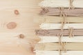 Different bundles of raw asian noodles close up on beige wooden board background, top view.