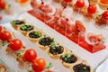different canapes in cups with sauce and tartlets with black caviar. Royalty Free Stock Photo