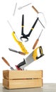 Different carpenter`s tools falling into wooden box on white background Royalty Free Stock Photo