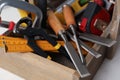 Different carpenter`s tools in wooden box on table, closeup