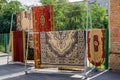 Different carpets hanging on rack outdoors. Professional carpet cleaning and drying Royalty Free Stock Photo