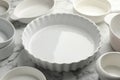 Different casseroles on white marble table, closeup Royalty Free Stock Photo