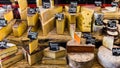 Different cheeses on the counter of a small store at the Aligre