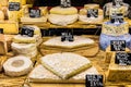 Different cheeses on the counter of a small store at the Aligre