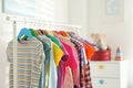 Different child`s clothes hanging on rack in room Royalty Free Stock Photo