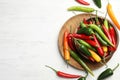 Different chili peppers on white table, flat lay. Space for text Royalty Free Stock Photo