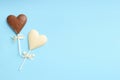 Different chocolate heart shaped lollipops on turquoise background, flat lay. Space for text Royalty Free Stock Photo