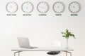 Different cities time on wall clock in modern office room with laptop on table and green plant in glass vase Royalty Free Stock Photo