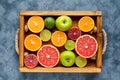 Different citrus fruit on a wooden box and grey concrete table. Food background. Healthy eating. Antioxidant, detox