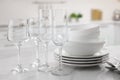 Different clean dishware, cutlery and glasses on white marble table in kitchen, closeup Royalty Free Stock Photo