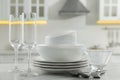 Different clean dishware, cutlery and glasses on white marble table in kitchen Royalty Free Stock Photo