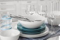 Different clean dishware, cutlery and glasses on white table in kitchen, closeup Royalty Free Stock Photo