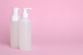 Different cleansers on pink background, space for text. Cosmetic product