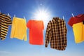 Different clothes drying on washing line against blue sky Royalty Free Stock Photo