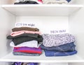 Different clothes in home wardrobe with paper notes. Small space organization. Vertical storage