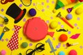 Different clown`s accessories on yellow background, flat lay