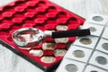 Different collector`s coins in the box for coins and a magnifying glass